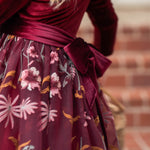 Close-up of embroidered floral detail on burgundy holiday dress