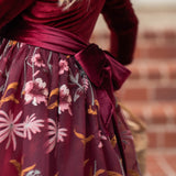 Close-up of embroidered floral detail on burgundy holiday dress