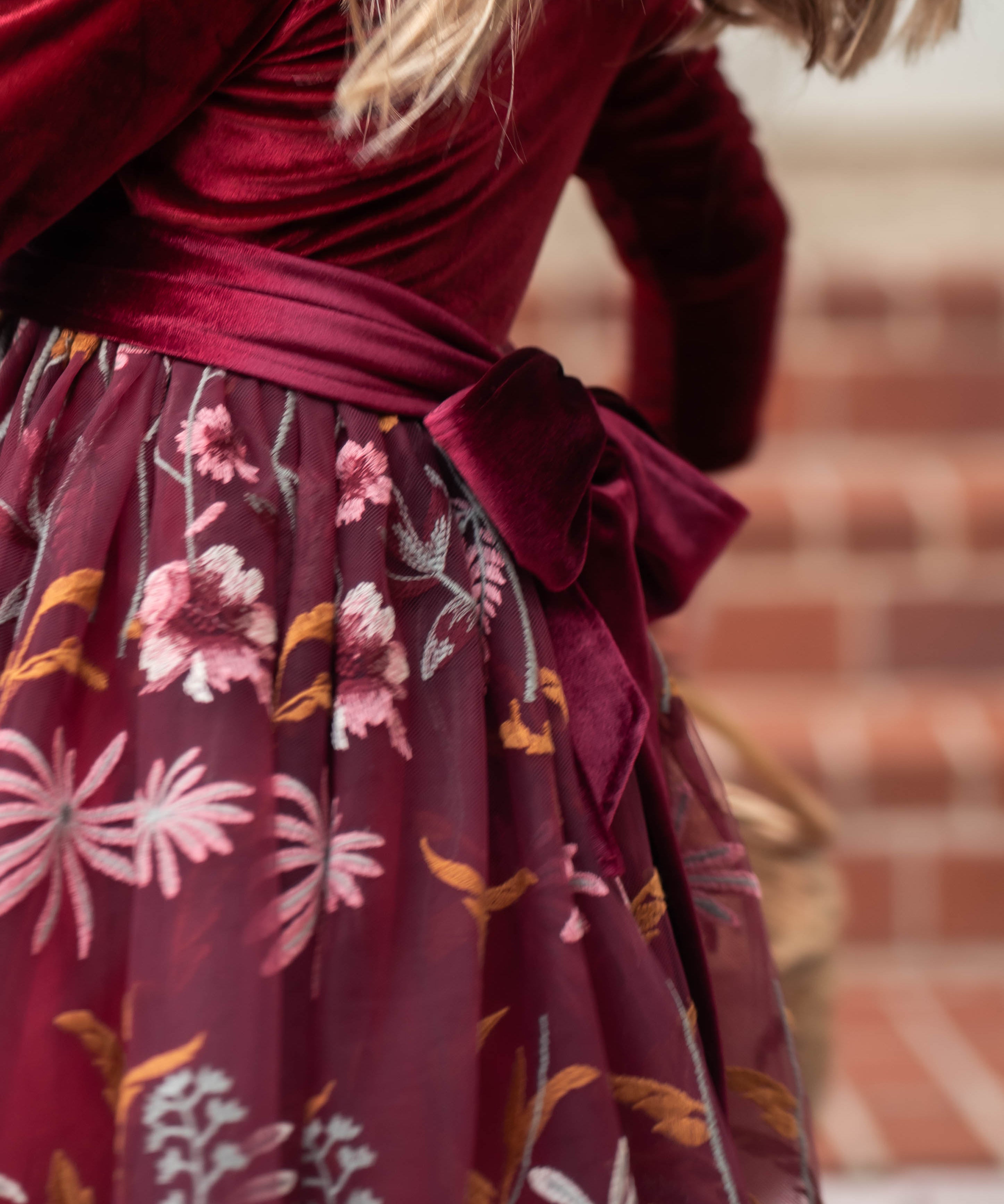 Close-up of embroidered floral detail on burgundy holiday dress