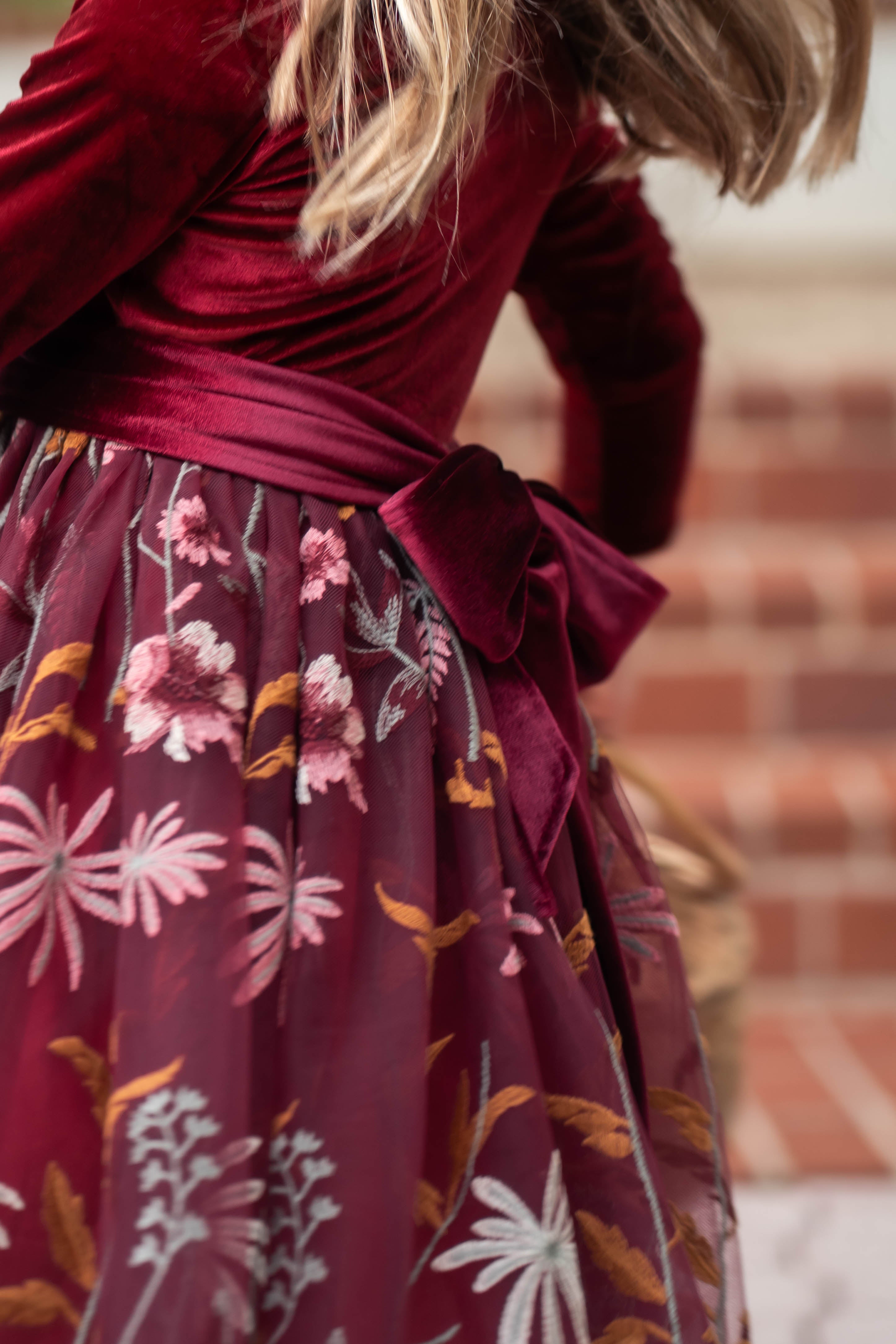 Close-up of embroidered floral detail on burgundy holiday dress
