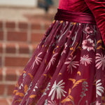 Plush velvet bodice of burgundy flower girl dress in warm glow